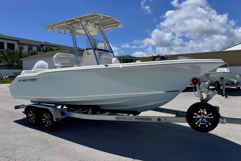 Slide: The Image of 2026 Key West 219 FS boat on trailer under clear blue sky. - 12