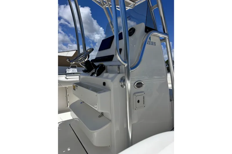 Slide: The Image of 2026 Key West 219 FS boat console with steering wheel and controls under blue sky. - 16