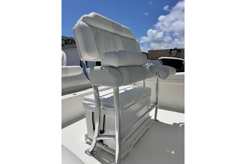 Slide: The Image of 2026 Key West 219 FS boat seat with cushioned backrest and storage, under a clear blue sky. - 17