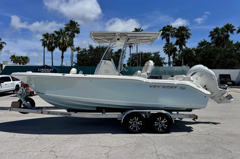 Slide: The Image of 2026 Key West 219 FS boat on trailer, parked outdoors under a clear sky. - 8