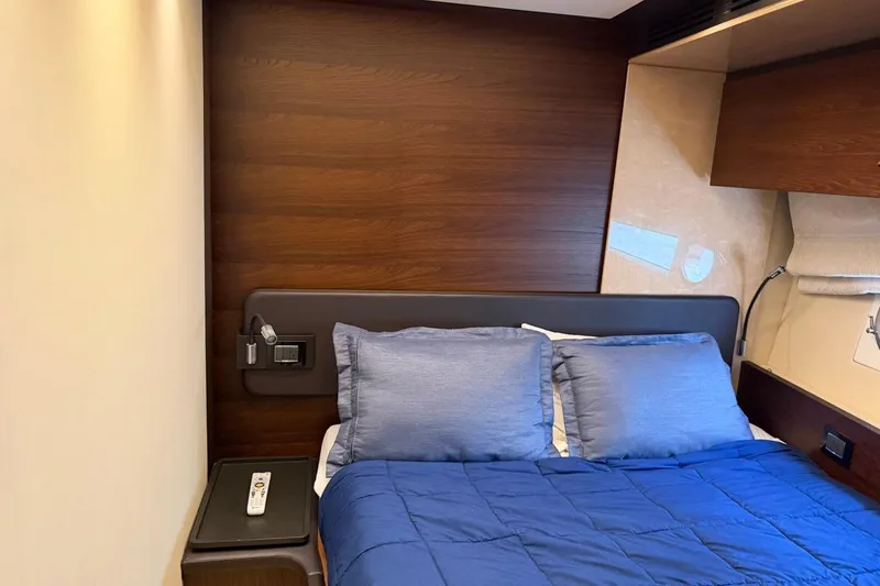Slide: The Image of Luxurious bedroom interior of 2017 Azimut Fly 72 yacht with blue bedding and wood accents. - 44