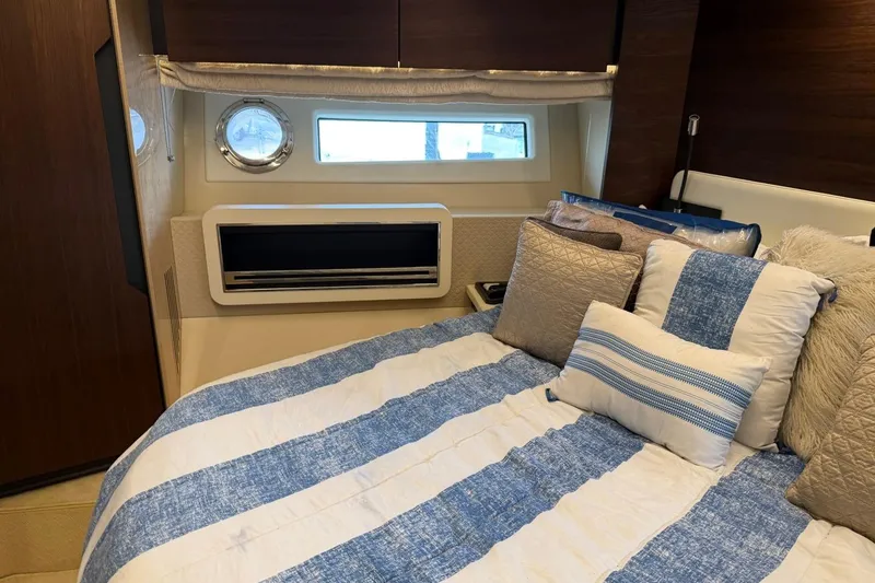 Slide: The Image of Luxurious bedroom interior of 2017 Azimut Fly 72 yacht with striped bedding and porthole window. - 48