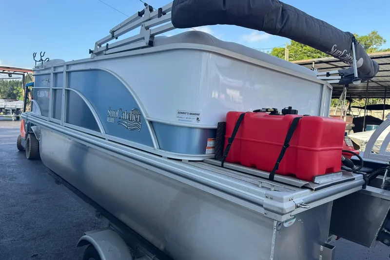 Slide: The Image of 2024 SunCatcher Select 16C pontoon boat with red fuel tanks on trailer. - 4