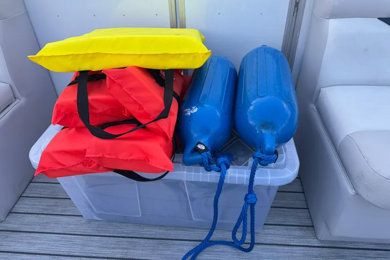 Slide: The Image of Safety gear on SunCatcher Select 16C boat, featuring life jackets and fenders, 2024 model. - 7