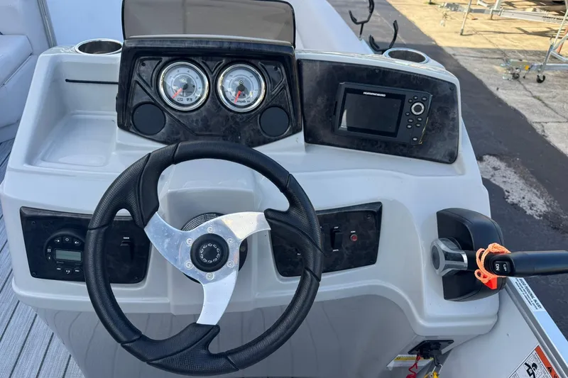 Slide: The Image of 2024 SunCatcher Select 16C boat dashboard with steering wheel and control panel. - 8
