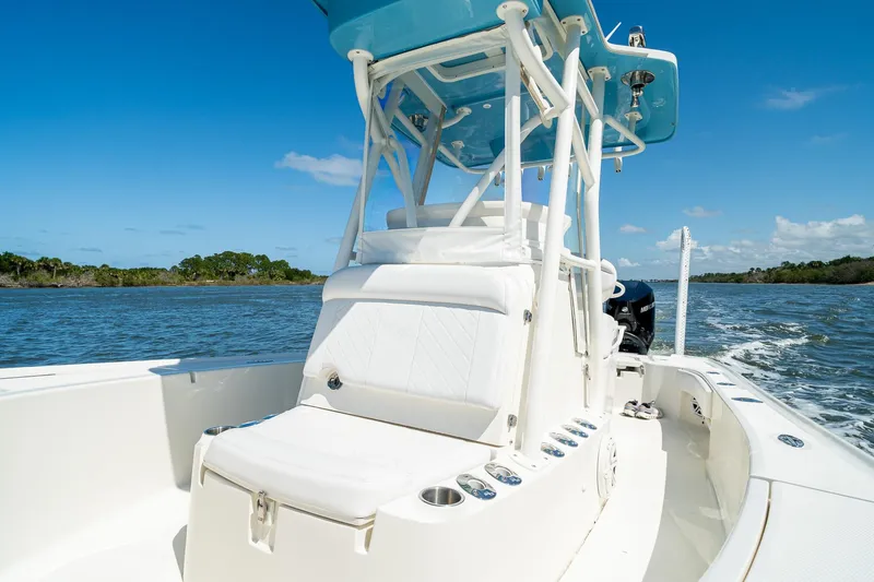Slide: The Image of 2018 SeaVee 270Z boat cruising on a sunny day, featuring sleek white design and blue canopy. - 21