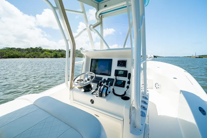 Slide: The Image of 2018 SeaVee 270Z boat cockpit with steering wheel and navigation equipment on calm water. - 25