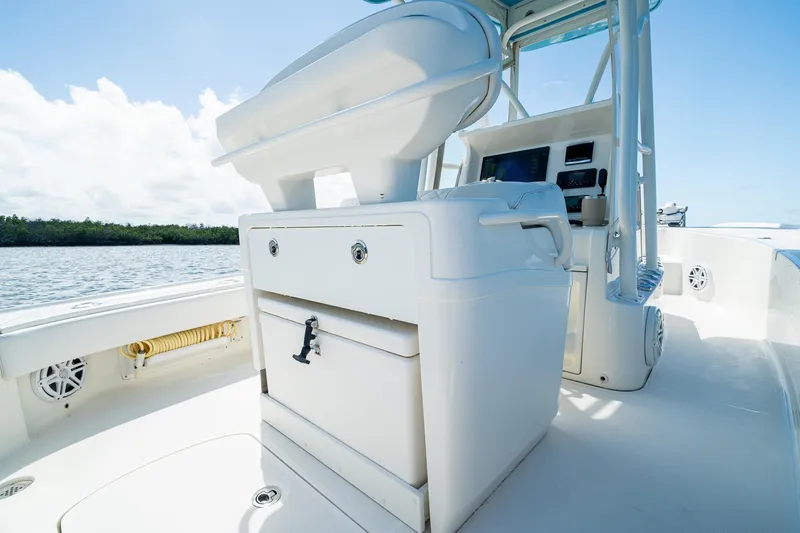 Slide: The Image of 2018 SeaVee 270Z boat interior with helm station and storage, set against a serene water backdrop. - 40
