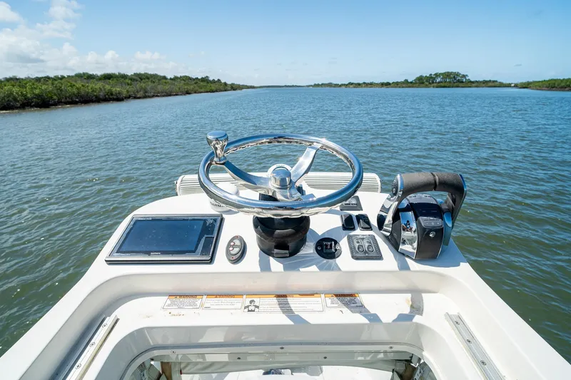 Slide: The Image of 2018 SeaVee 270Z boat helm with steering wheel and controls on open water. - 48