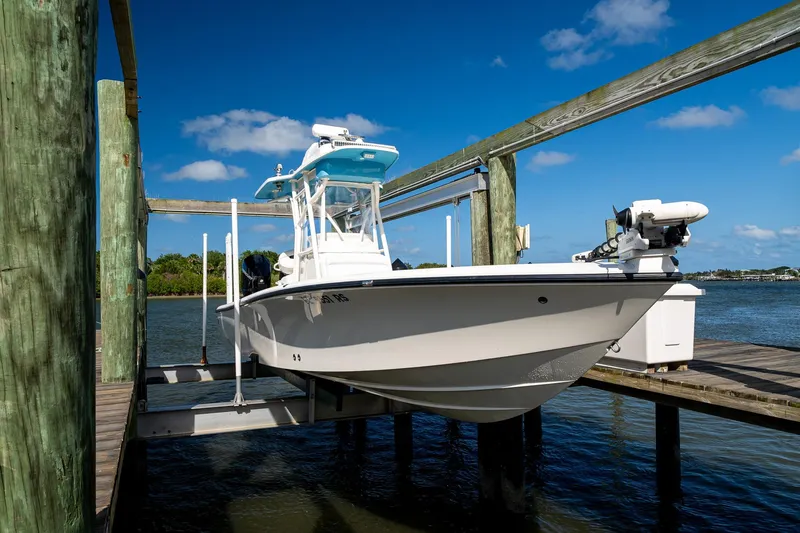 Slide: The Image of 2018 SeaVee 270Z boat on lift, docked by the water under a clear blue sky. - 61