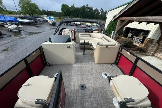 Slide: The Image of 2022 Viaggio Lago 18F pontoon boat with beige seating and red accents at a marina. - 5