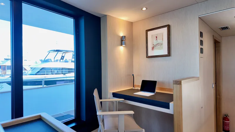 Slide: The Image of Interior of LEEN-TRIMARANS 72, 2024, featuring desk and window view. - 12