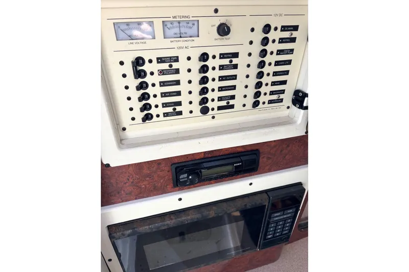 Slide: The Image of 1997 Donzi 255 LXC control panel with switches, gauges, and a microwave. - 12