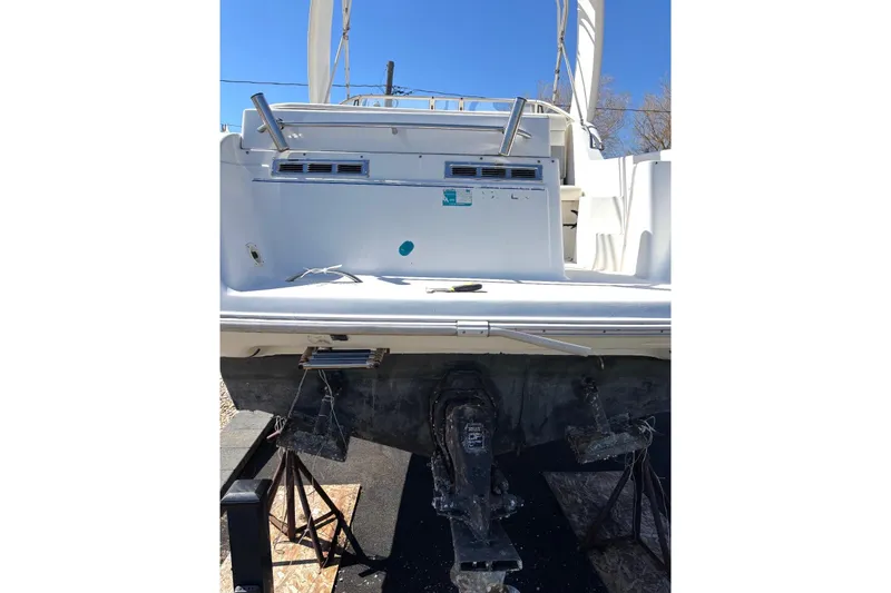 Slide: The Image of 1997 Donzi 255 LXC boat on stands, rear view, under clear blue sky. - 3
