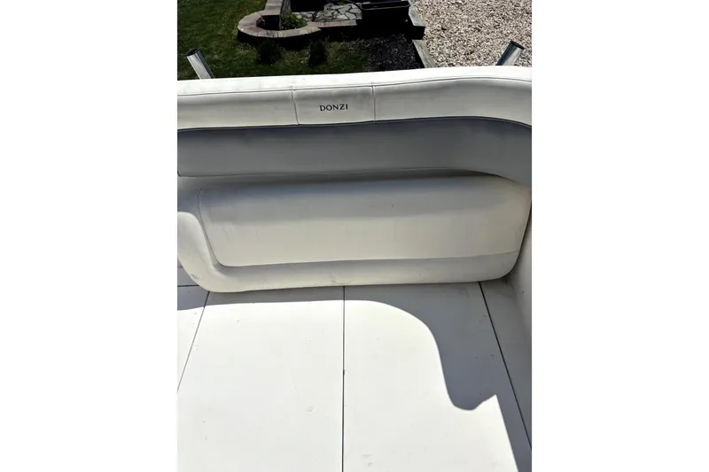 Slide: The Image of 1997 Donzi 255 LXC boat interior with white seating and outdoor background. - 4