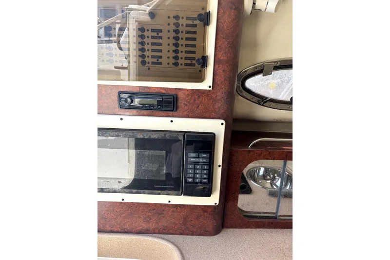 Slide: The Image of 1997 Donzi 255 LXC interior with control panel, microwave, and porthole window. - 6