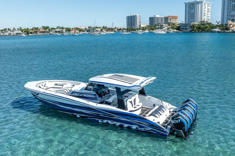 Slide: The Image of 2024 MTI V42 boat on clear blue water near city skyline. - 2