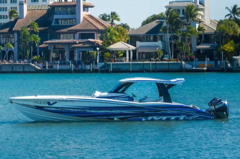 Slide: The Image of 2024 MTI V42 boat on water with luxury waterfront homes in the background. - 5