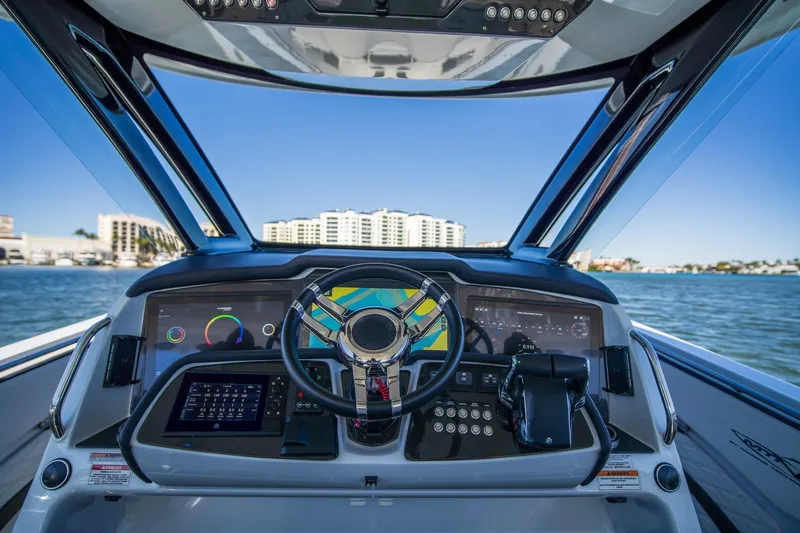 Slide: The Image of 2024 MTI V42 boat dashboard with advanced navigation system and scenic waterfront view. - 6