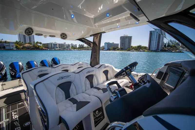 Slide: The Image of Luxurious 2024 MTI V42 boat interior with plush seating and modern controls on a sunny waterfront. - 9