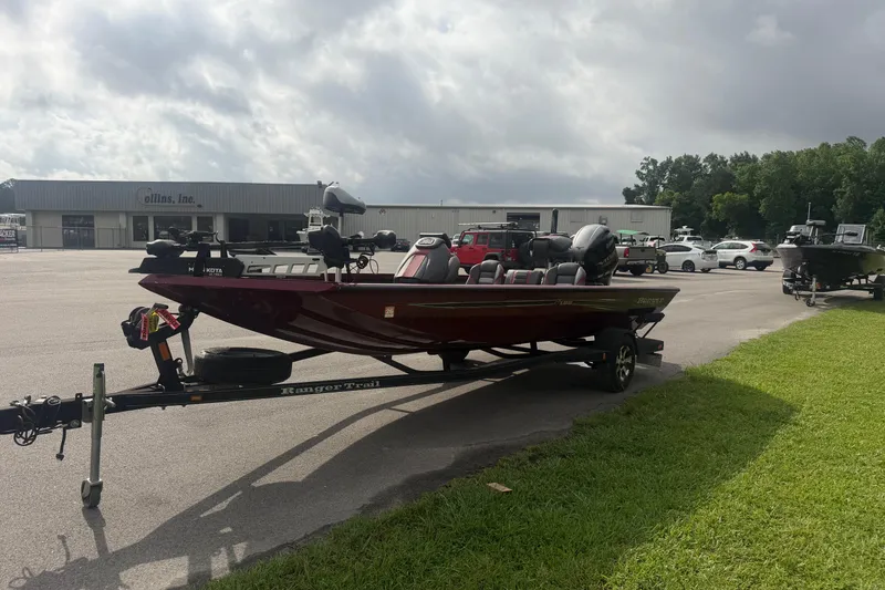 Slide: The Image of 2019 Ranger RT188 boat on trailer in parking lot, cloudy sky background. - 2