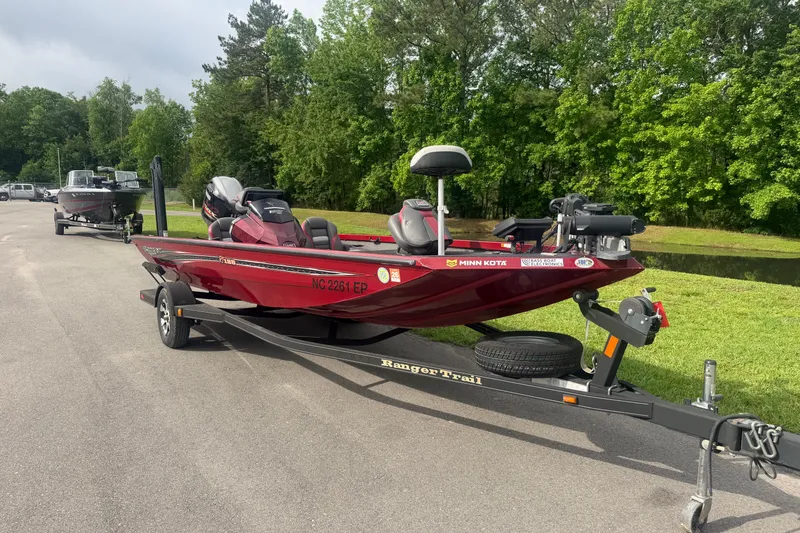 Slide: The Image of 2019 Ranger RT188 boat on trailer, parked on road near lush green trees. - 4