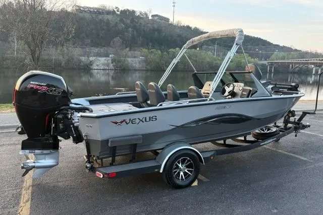 Slide: The Image of 2023 Vexus ADX 190 boat on trailer by a scenic river. - 2