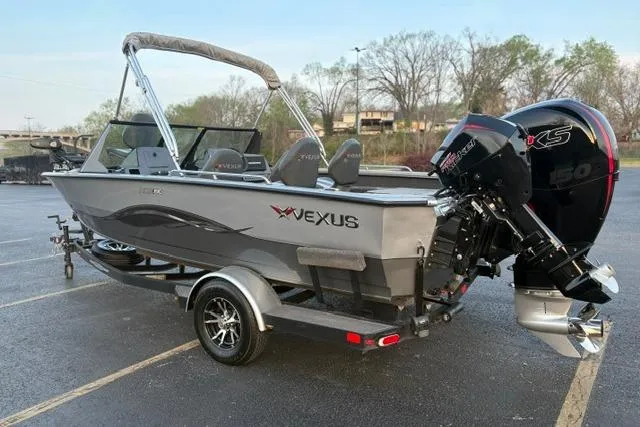 Slide: The Image of 2023 Vexus ADX 190 boat with outboard motor, parked on a trailer in a lot. - 3
