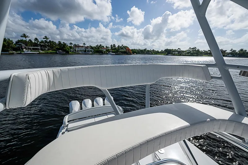 Slide: The Image of 2022 Bahama 41 boat with white seating, overlooking a scenic waterfront view. - 17