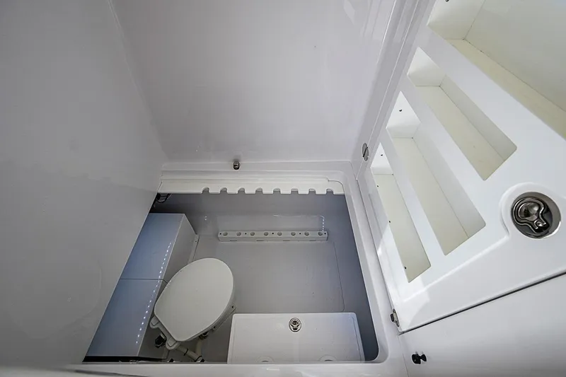 Slide: The Image of Interior of 2022 Bahama 41 boat bathroom with toilet and storage shelves. - 18