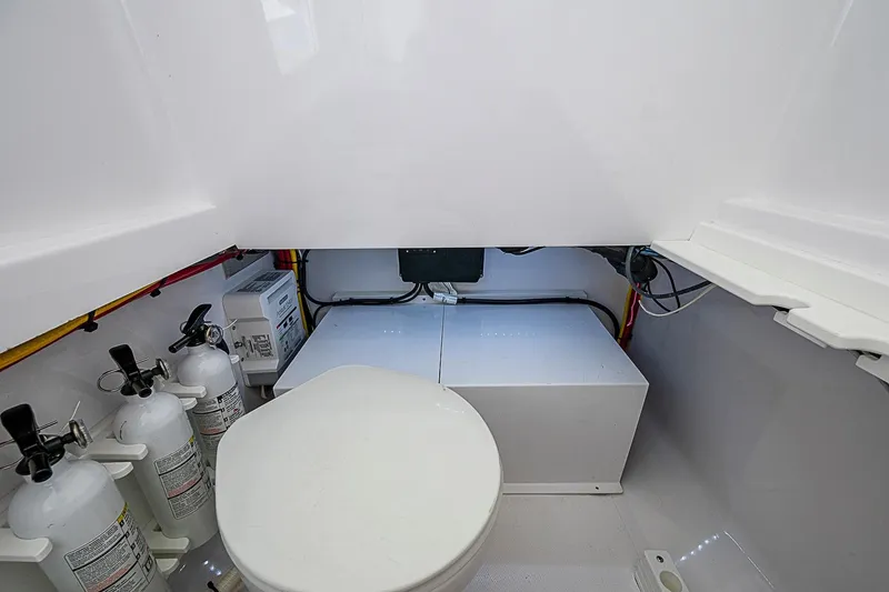 Slide: The Image of 2022 Bahama 41 boat interior with toilet and fire extinguishers in a compact space. - 19