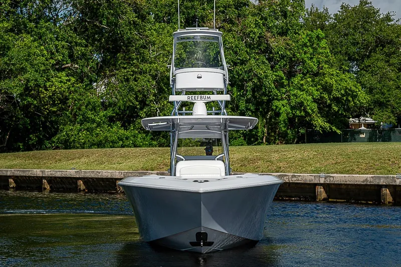 Slide: The Image of 2022 Bahama 41 boat on water, surrounded by lush greenery. - 2