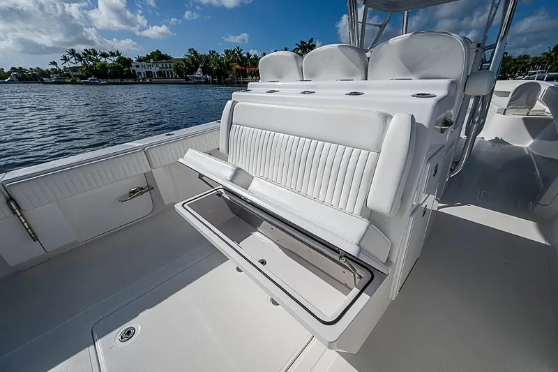 Slide: The Image of 2022 Bahama 41 boat interior with open storage compartment, white seating, and scenic water view. - 22