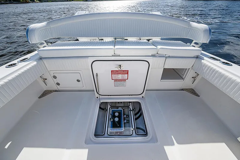 Slide: The Image of 2022 Bahama 41 boat interior with storage compartments and seating, on a calm water backdrop. - 24