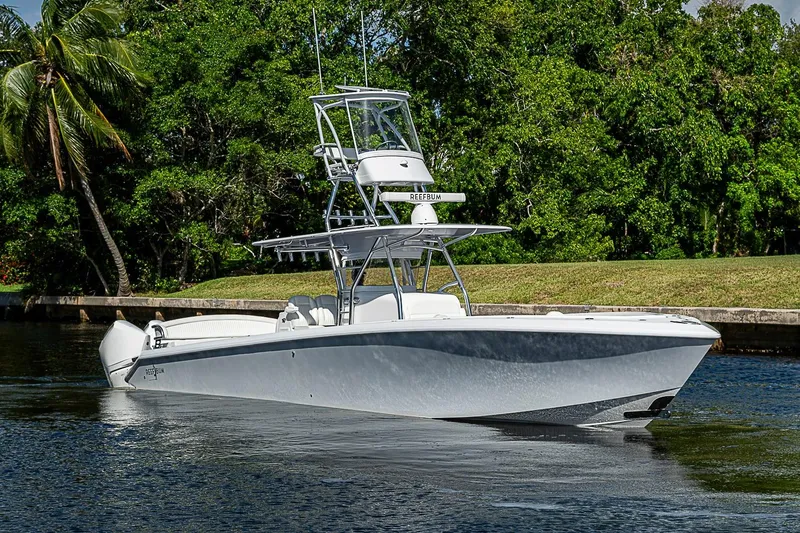Slide: The Image of 2022 Bahama 41 boat cruising on a calm waterway, surrounded by lush greenery. - 33