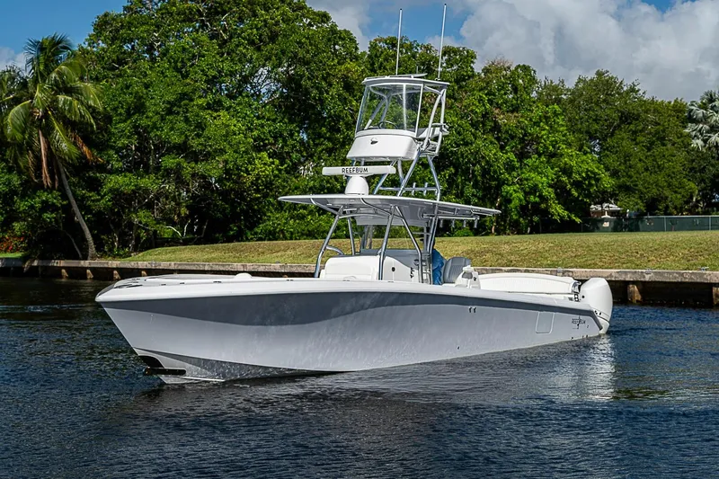 Slide: The Image of 2022 Bahama 41 boat cruising on a calm waterway with lush greenery background. - 34