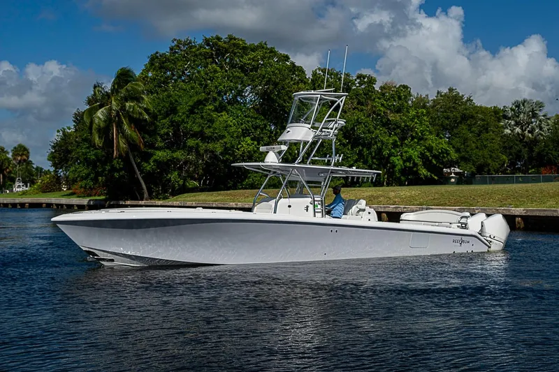 Slide: The Image of 2022 Bahama 41 boat cruising on a calm waterway with lush greenery backdrop. - 35