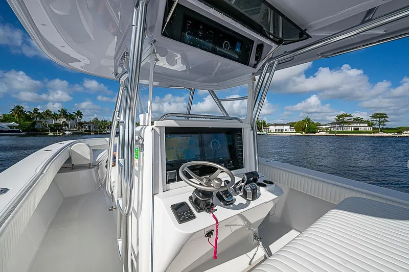 Slide: The Image of 2022 Bahama 41 boat cockpit with modern navigation system, steering wheel, and waterfront view. - 9