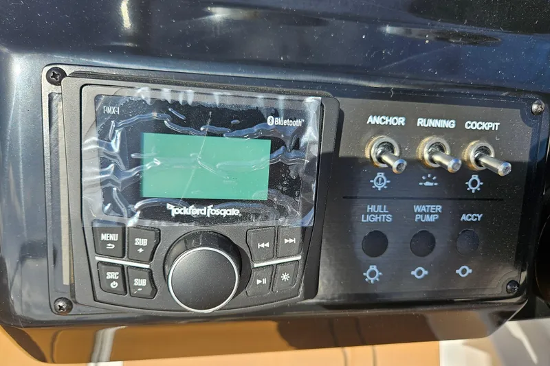 Slide: The Image of Control panel of a 2026 Bayliner V20 boat with audio system and switches. - 7