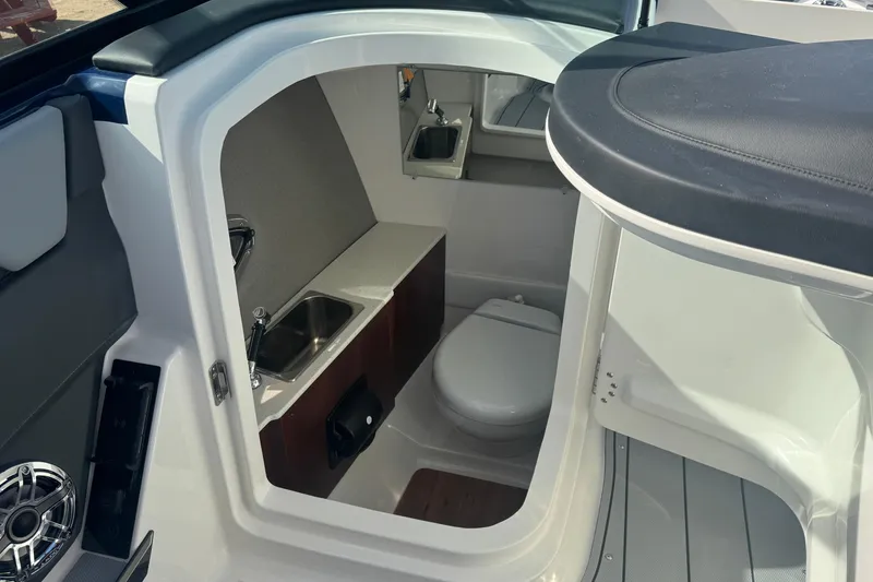 Slide: The Image of Interior of 2026 Chaparral SSX 30 boat featuring a compact bathroom with sink and toilet. - 25