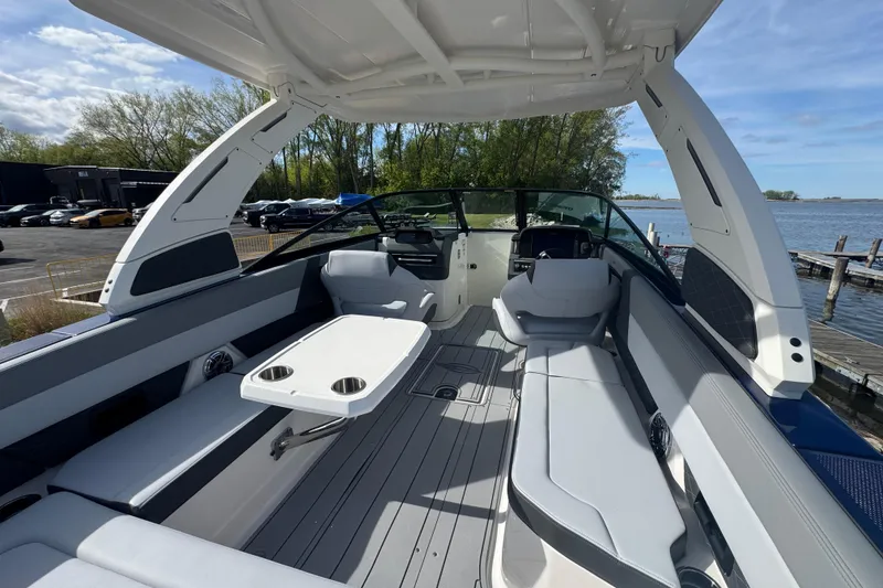 Slide: The Image of 2026 Chaparral SSX 30 boat interior with sleek seating and a central table, dockside view. - 4