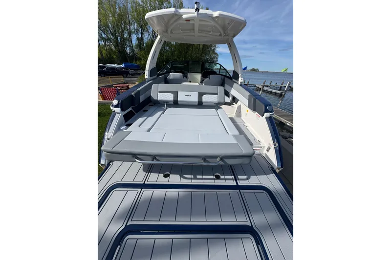 Slide: The Image of 2026 Chaparral SSX 30 boat with spacious deck and seating, docked by a lake. - 5