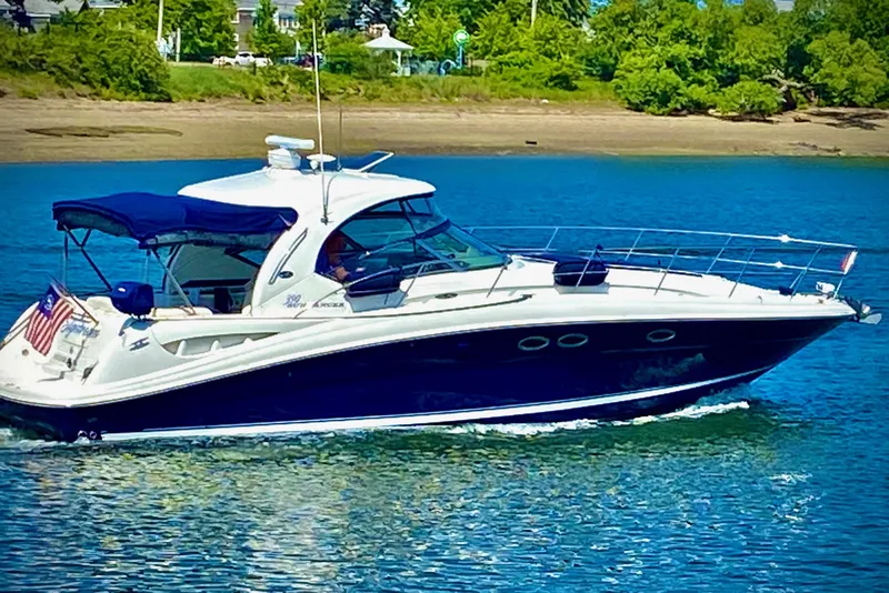 The Image of 2005 Sea Ray 390 Sundancer cruising on a sunny day, surrounded by lush greenery. - 0
