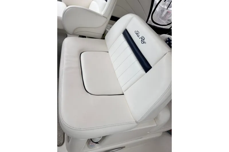 Slide: The Image of White leather seat on 2005 Sea Ray 390 Sundancer boat, featuring embroidered logo. - 10