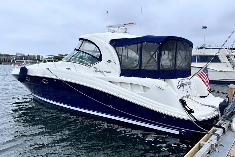 Slide: The Image of 2005 Sea Ray 390 Sundancer yacht docked at marina, featuring sleek design and blue hull. - 2