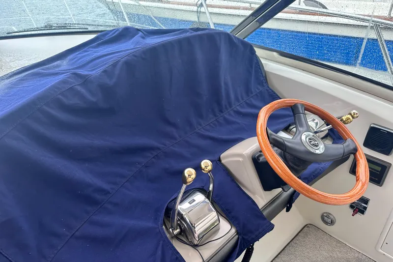 Slide: The Image of Helm of 2005 Sea Ray 390 Sundancer with covered controls and wooden steering wheel. - 6