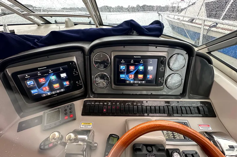 Slide: The Image of Helm of 2005 Sea Ray 390 Sundancer with dual Raymarine displays and wooden steering wheel. - 7
