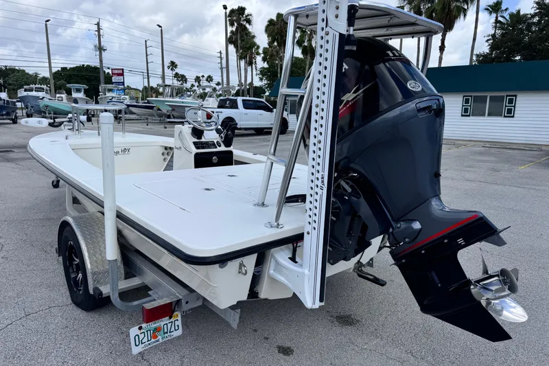 Slide: The Image of 2022 Maverick 18 HPX-V boat with outboard motor, parked on a trailer in a lot. - 10