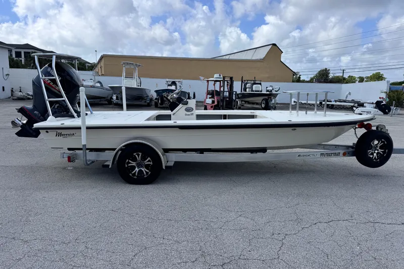 Slide: The Image of 2022 Maverick 18 HPX-V boat on trailer, parked outdoors under a cloudy sky. - 13