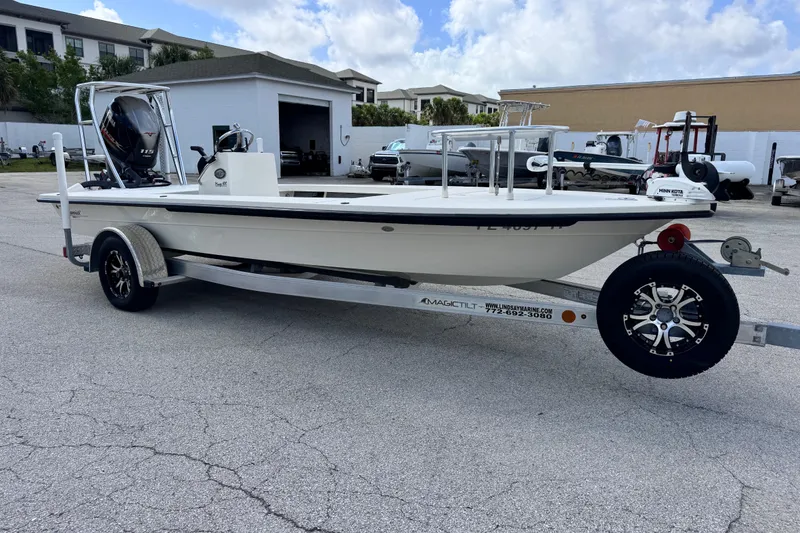 Slide: The Image of 2022 Maverick 18 HPX-V boat on trailer, parked outdoors under a cloudy sky. - 14